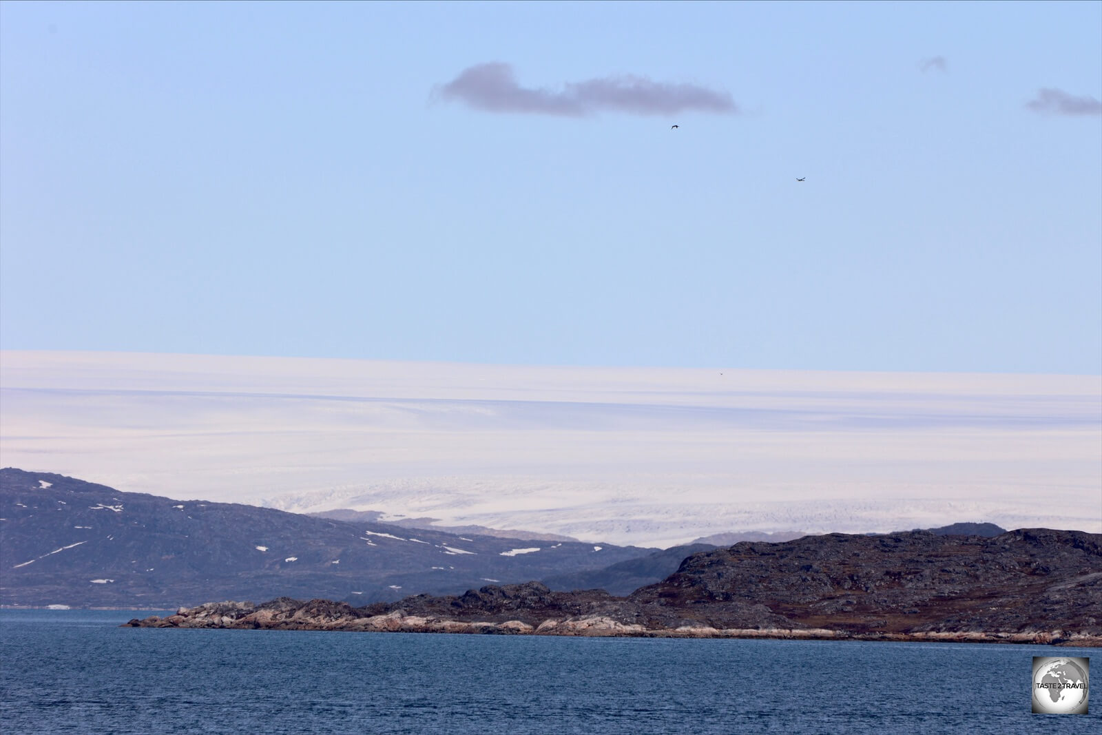 As seen from the Sarfaq Ittuk, the towering, Greenland Ice Sheet looks like icing on a wedding cake.