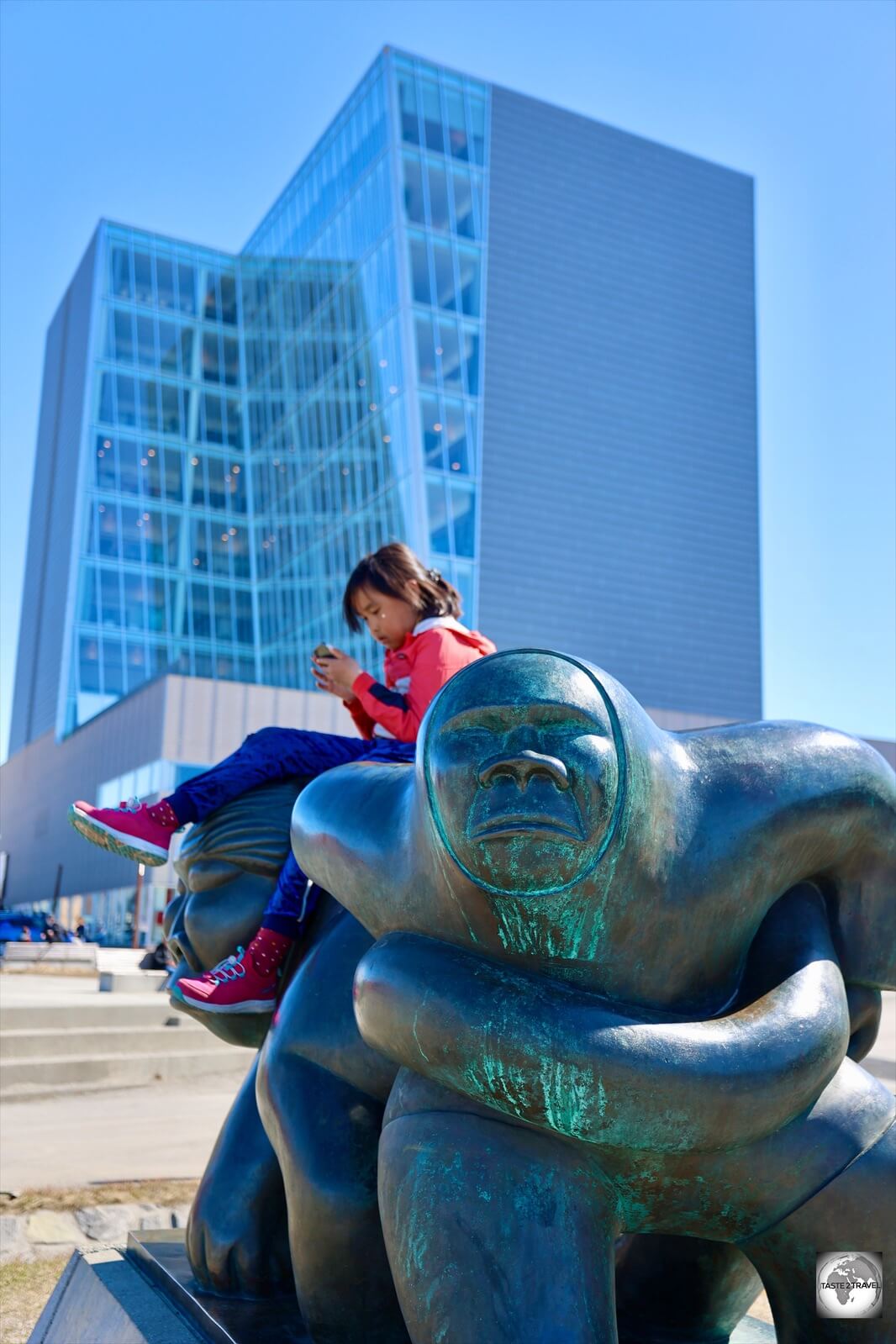 A statue in Nuuk provides the perfect seat for a young Inuit girl.