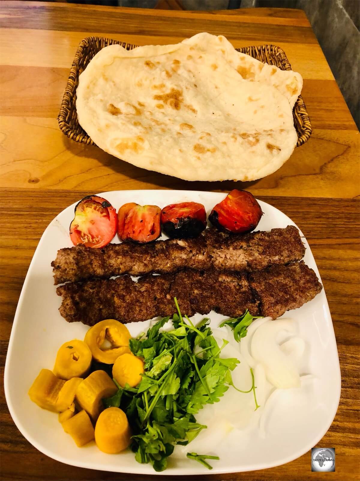 Typical meal of shish kebab, salad, pickled vegetables and flat bread.