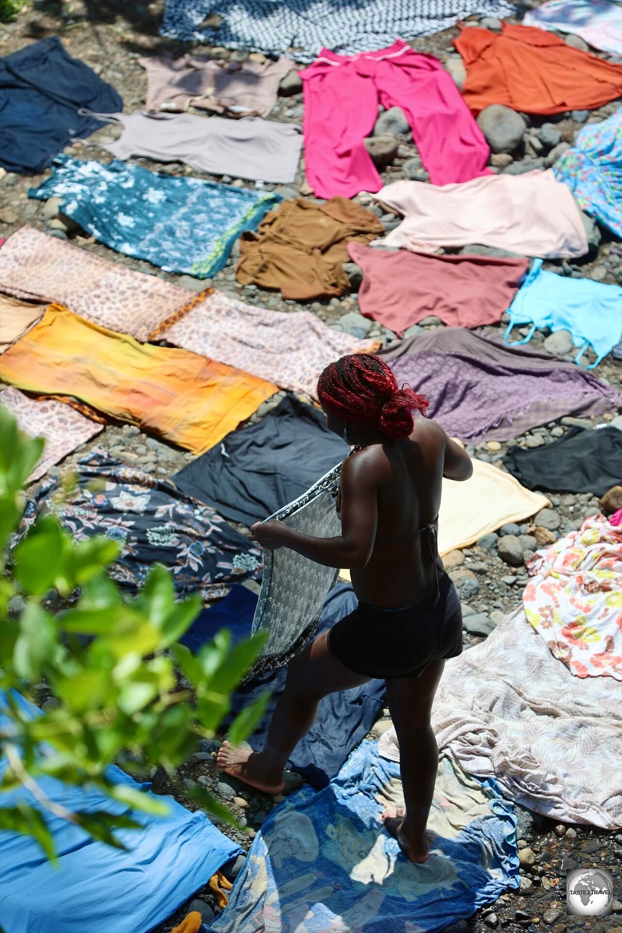 Laying out the wet clothes to dry in the sun on the hot river stones.