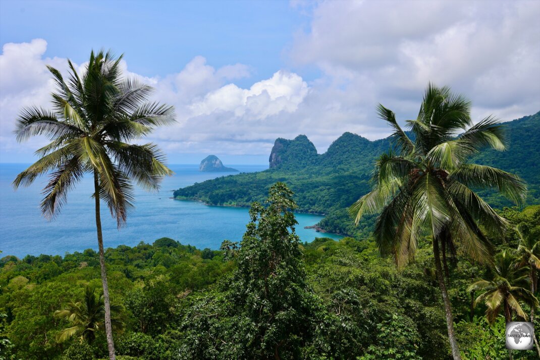 A panoramic view of Principe Island and the distant Caroço Island, a steep, rocky, wooded islet which rises to 305 metres elevation.