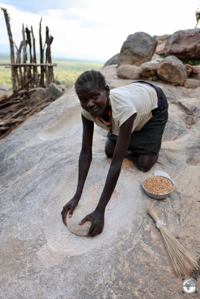 A young Lotuko girl, grinding grain.