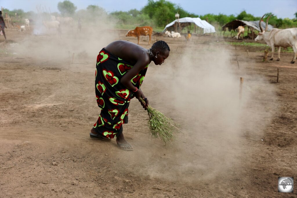 A Mundari girl, sweeping the camp grounds.