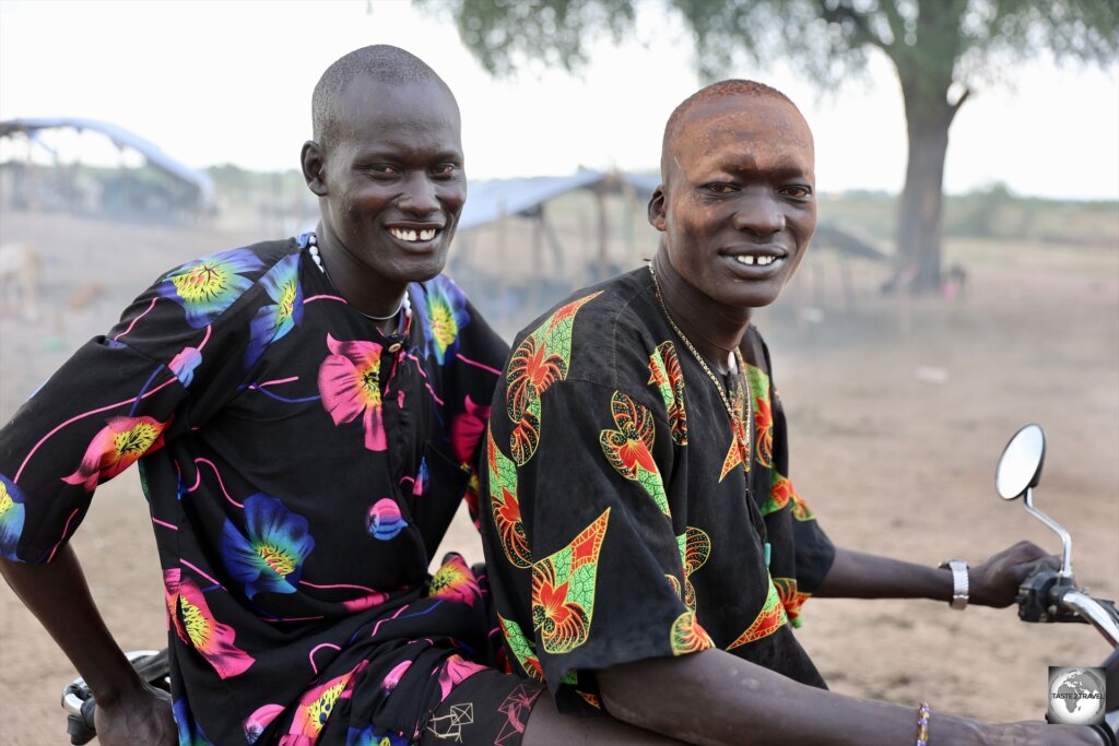 Two, very fashionable, Mundari cattle herders on a motorbike.